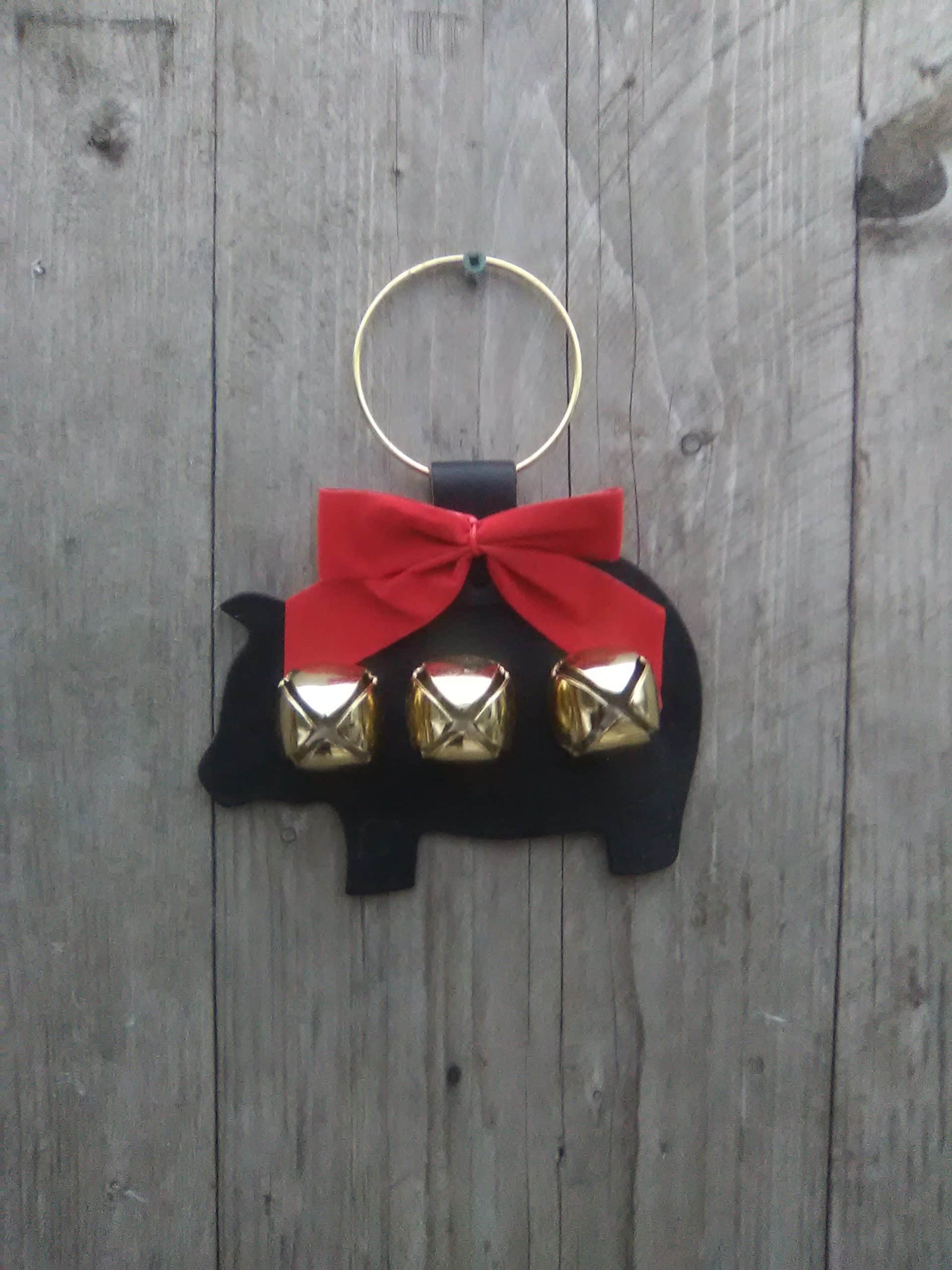Made with thick black harness leather, brass plated bells, riveted ring and red bow. Piglet Door Hanger