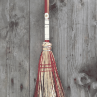 Whisk broom with handle and splash of red