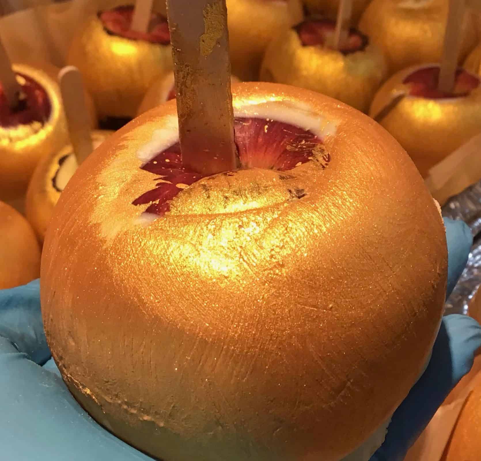 Golden edible apple with popsicle stick skewer